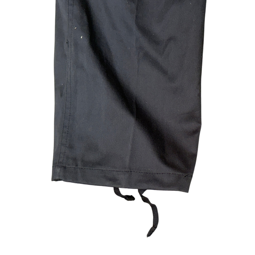 Close-up of a black fabric garment leg with a drawstring hem, shown against a plain white background.
